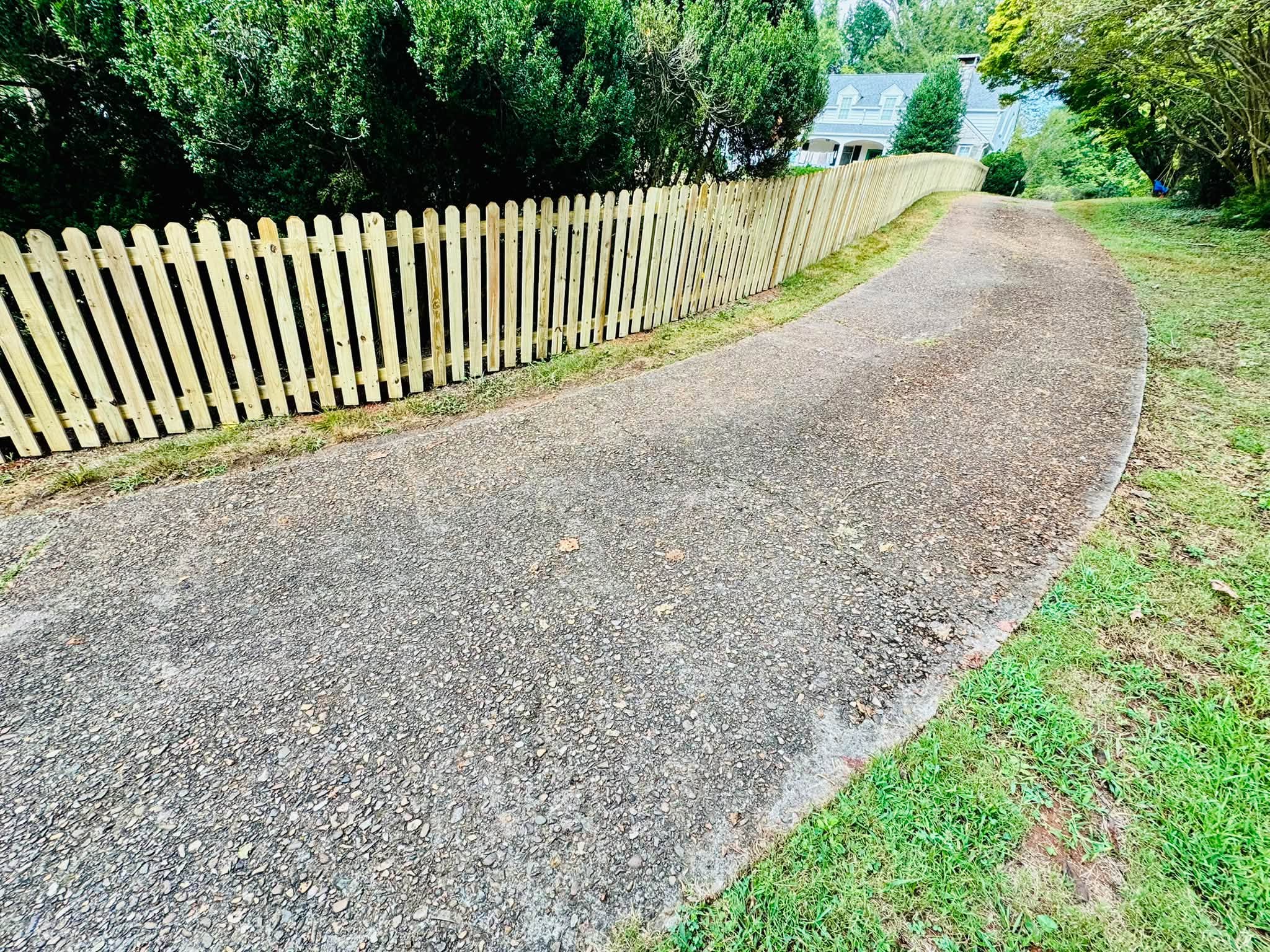 New wood picket fence along a driveway in Athens, Tennessee, built by Athens Fence Company